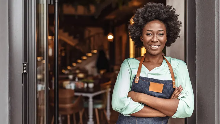 A female business owner standing outside of her business