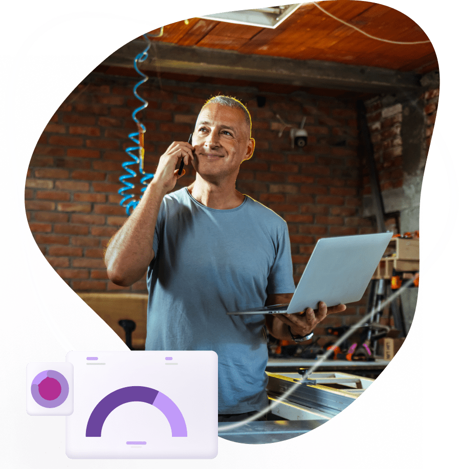 Home service business owner on the phone while checking reports on a laptop