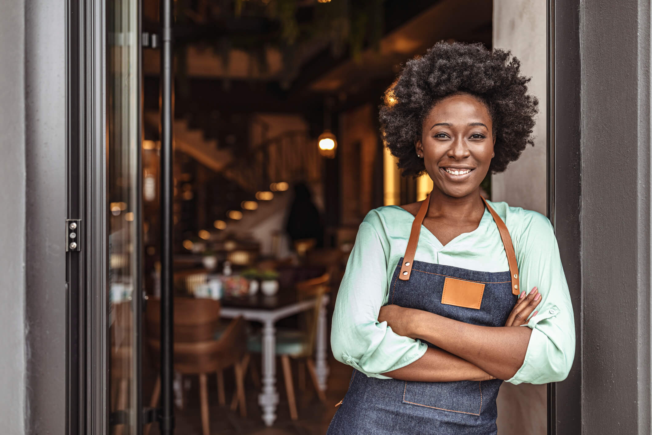 A female business owner standing outside of her business